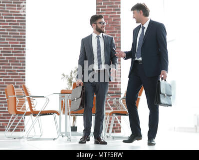 Deux hommes d'en marchant le long d'un immeuble de bureaux moderne Banque D'Images