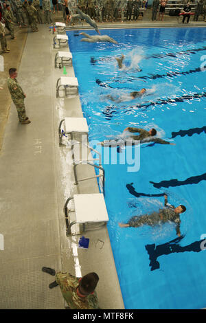 Des soldats américains avec le 20ème commandement CBRNE, commencer la partie natation de 100 mètres de la compétence des Forces armées allemandes (Badge) GAFPB à la Central Washington University, Ellensburg, Washington, le 23 avril 2017. Le GAFPB nager exige que les participants à nager en uniforme, sans bottes, pour 100 mètres en moins de quatre minutes, puis déposer l'uniforme dans l'extrémité profonde sans tenir les bords de la piscine. Banque D'Images