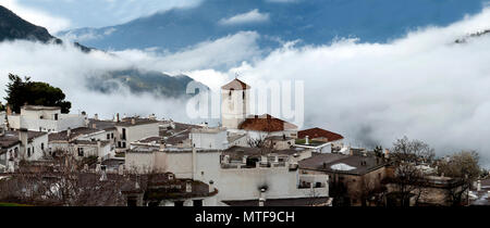 Le village de Capileira Alpujarran, avec son église catholique dans la brume, là-haut, dans les montagnes de la Sierra Nevada en Espagne, Andalousie région. Banque D'Images