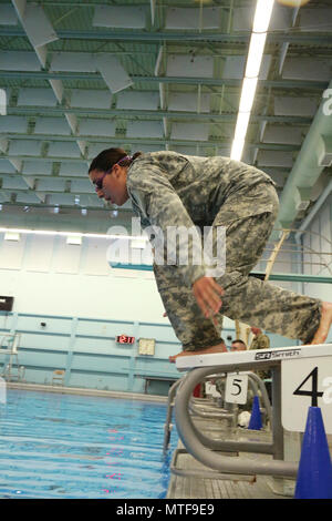 Un soldat américain avec le 20ème commandement CBRNE, plongeons dans la piscine pour commencer la partie natation de 100 mètres de la compétence des Forces armées allemandes (Badge) GAFPB à la Central Washington University, Ellensburg, Washington, le 23 avril 2017. Le GAFPB nager exige que les participants à nager en uniforme, sans bottes, pour 100 mètres en moins de quatre minutes, puis déposer l'uniforme dans l'extrémité profonde sans tenir les bords de la piscine. Banque D'Images