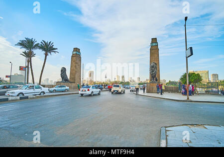 Le CAIRE, ÉGYPTE - Le 24 décembre 2017 : l'occupé El Tahrir street, décorées avec des tours en pierre et sculprtures des lions à l'entrée du pont Qasr El Nil, Banque D'Images