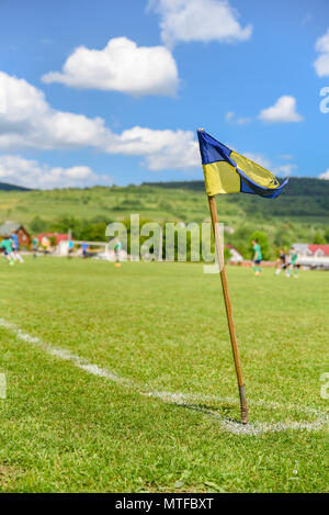 Terrain de soccer amateur rétro, poteau de coin sur le premier plan, les joueurs de football se battent pour la balle de l'arrière-plan. Des histoires sur la vie rurale dans l'U Banque D'Images