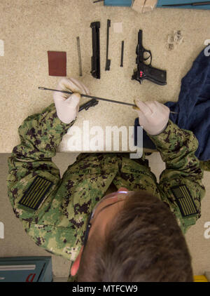 MANAMA, Bahreïn (24 avril 2017) Mate du canonnier matelot Braden Maynard, attribué à munitions du détachement de la marine commande Bahreïn, nettoie une M9 Beretta pistolet 9 mm après avoir terminé un cours de qualification d'armes légères et de petit calibre à l'éventail sur la base navale américaine (NSA) BAHREÏN 24 Avril. Banque D'Images