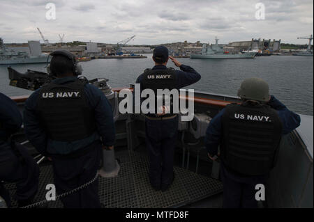 Royaume-uni (24 avril 2017) Le Cmdr. Tyson Young, centre, de la direction de la classe Arleigh Burke destroyer lance-missiles USS Carney (DDG 64), rend honneur aux navires de la Marine royale comme le navire quitte Plymouth, Royaume-Uni. Carney est l'avant-déployé à Rota, en Espagne, en effectuant sa 3ème patrouille dans la sixième flotte américaine zone d'opérations à l'appui de la sécurité nationale des États-Unis en Europe. Banque D'Images