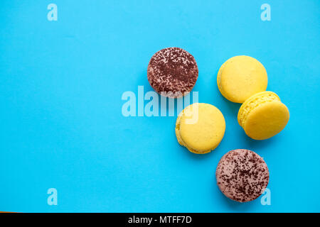 Gâteau macarons colorés, vue du dessus télévision lay, macaron sucré sur fond bleu couleur isolé de bonbons. Modèle contenus concepts ci-dessus, l'arrière-plan de l'alimentation. L'espace de copie . Dessert français. Banque D'Images