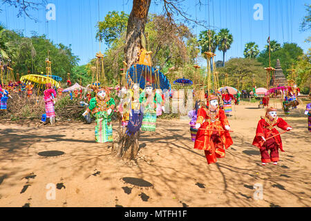 Marionnettes traditionnels fabriqués à la main dans des robes colorées et lumineuses parasols accrocher sur l'arbre et de flottement sur le vent en site archéologique de vieux sac Banque D'Images