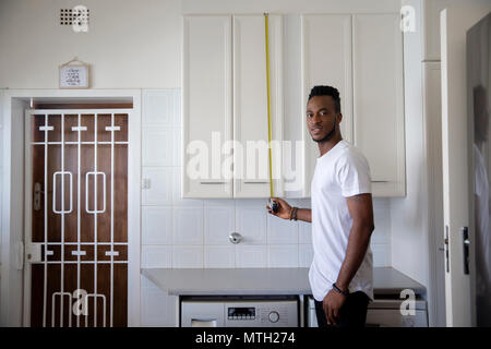 La mesure de l'homme d'armoires de cuisine Banque D'Images