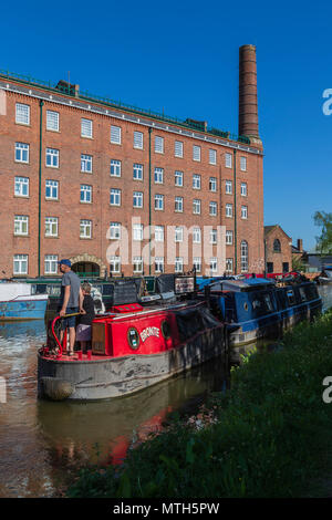 Macclesfield sur un canal clair et ensoleillé matin mai avec les barges et Vieux Moulin Hovis dans l'arrière-plan Banque D'Images