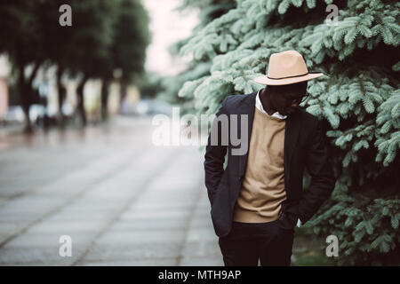 Homme beau dans des vêtements et des lunettes de soleil la marche à l'extérieur dans la rue Banque D'Images