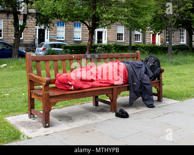 Un dormeur sur un banc de parc dans la ville nouvelle, Édimbourg, Écosse, Royaume-Uni Banque D'Images