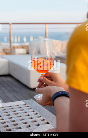 La main féminine avec verre d'Aperol spritz Banque D'Images