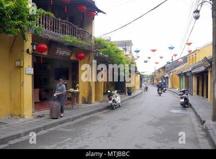 HOI AN, VIETNAM - 17ème Mars 2018 : femme en prière et de brûler des papiers pour de bonnes affaires dans l'avant du restaurant à Hoi An Banque D'Images