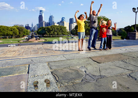 Family posing à côté de l'empreinte de Sylvester Stallone à Rocky étapes - rendu célèbre dans le film Rocky Balboa, Philadelphia, Pennsylvania, USA Banque D'Images