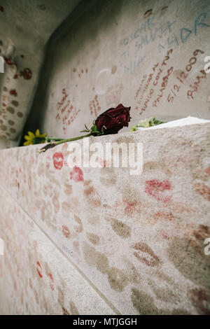 Une rose rouge à gauche Oscar Wildes tombeau couvert de coeurs et kiss marques en cimetière du Père Lachaise, Paris, France Banque D'Images