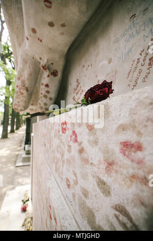 Une rose rouge à gauche Oscar Wildes tombeau couvert de coeurs et kiss marques en cimetière du Père Lachaise, Paris, France Banque D'Images