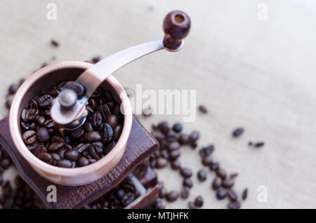 Les grains de café torréfiés et moulin à café en bois sur fond rustique with copy space Banque D'Images