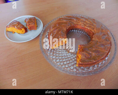 Le gâteau à la forme d'un anneau se trouve sur un plat en verre transparent. Et deux morceaux coupés sur une petite soucoupe de côté. Banque D'Images