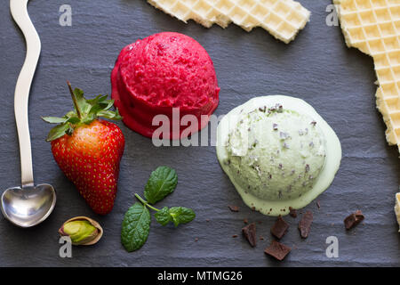 Menthe fraise résumé la glace fondante de la crème sur du marbre noir concept still life Banque D'Images