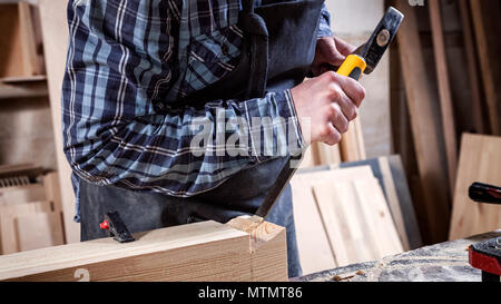 Strong carpenter en bois Sculpture sur les vêtements de travail à l'aide d'un outil à bois, ciseau, mains close up, menuiserie et artisanat concept Banque D'Images