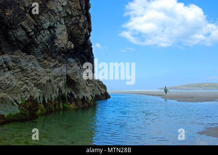 Une femme marche au pied des falaises sur la plage Maghera, Ardara, comté de Donegal, en Irlande. Banque D'Images