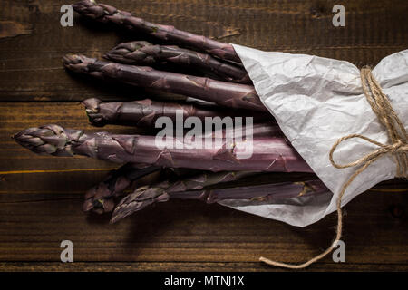 Asperges violettes ligne Close Up sur fond de bois Banque D'Images