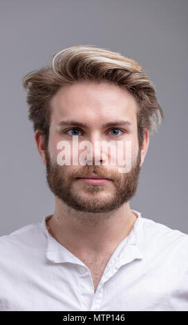 Studio shot portrait d'un beau jeune homme barbu pense à l'avenir contre fond beige pour copy space Banque D'Images