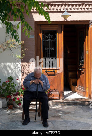 Portrait d'un homme âgé assis au repos dans la place du village à Omodos, Cypru Banque D'Images