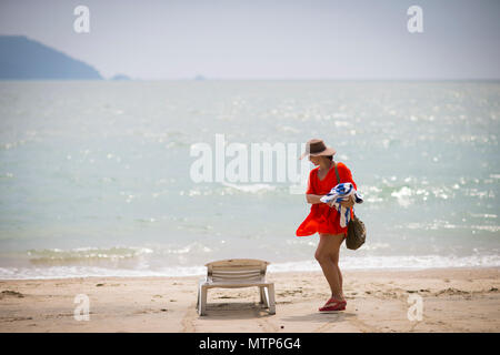Une femme blonde déambule le long de la plage au Damai Laut en Malaisie. Banque D'Images