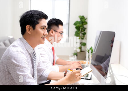 Image de deux jeunes hommes d'interaction at meeting in office Banque D'Images