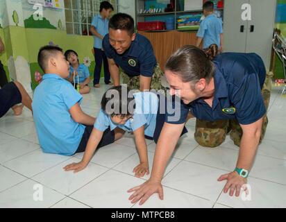 180521-N-NH199-0093 NHA TRANG, Vietnam (21 mai 2018) Le lieutenant-colonel Karen Tel, à Sydney, en Australie (à droite), et l'Intelligence Specialist 1re classe Bihn Phan (à gauche), de Phoenix, tous deux attribués à la commande de transport maritime militaire navire-hôpital USNS Mercy (T-AH 19) pour le Partenariat du Pacifique 2018 (PP18), d'interagir et de jouer à des jeux avec les élèves de Cam Lam Centre du District de la réhabilitation et de l'éducation pour les enfants handicapés, au cours d'un événement de relations communautaires et de la bande de performance. PP18's mission est de travailler ensemble avec l'hôte et les pays partenaires à améliorer l'interopérabilité régionale et la réaction aux catastrophes ca Banque D'Images