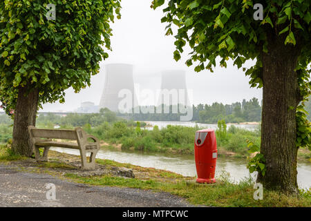 Centrale nucléaire de Belleville sur les bords de la Loire par temps brumeux avec un banc en béton et une bouche d'incendie sur le quai dans l'avant-plan. Banque D'Images