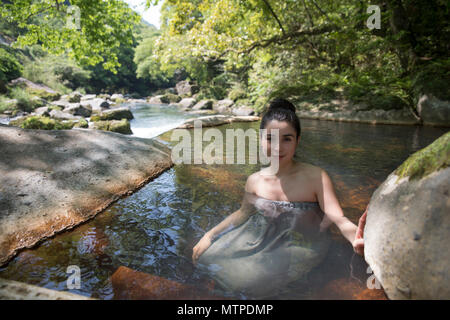 Woman bathing in outdoor onsen / Hot Spring à Myoken Ishikaraso, Kirishima, Kyushu, Japon Banque D'Images