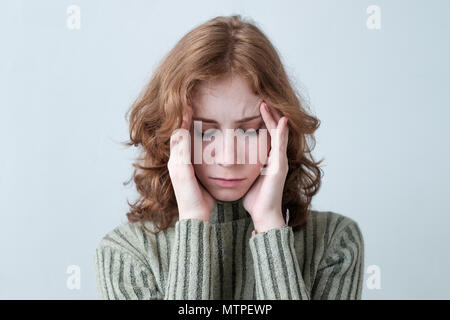 Young caucasian woman with red cheveux bouclés holding head de la douleur sur fond blanc. Banque D'Images