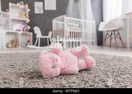 Vue d'un ours en peluche rose portant sur un étage dans une chambre bébé moderne Banque D'Images