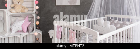 Chambre de bébé avec un mobilier en bois simple, décorations élégantes et ciment wall design Banque D'Images