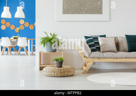 Salon lumineux contemporain en blanc et bleu avec la table, les plantes, pouf, salle à manger ouverte avec table et chaises Banque D'Images