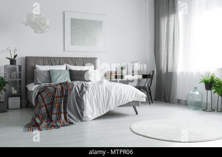 Fenêtre avec rideaux gris et blanc dans cette chambre spacieuse avec lit double Banque D'Images