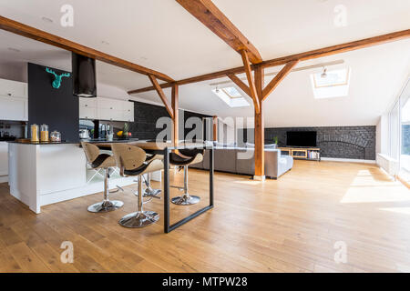 Tabourets de bar moderne à table à manger dans cet appartement spacieux avec cuisine et salle de séjour Banque D'Images