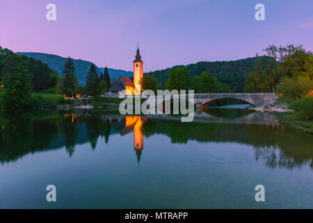 L'église Saint Jean le Baptiste au lac de Bohinj. Le lac de Bohinj est le plus grand lac permanent en Slovénie. Il est situé dans la vallée de Bohinj de th Banque D'Images