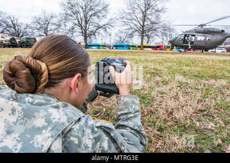 Le sergent de l'armée américaine. Tianna Waite de Portland en Oregon, un radiodiffuseur affecté à la 41e Brigade d'infanterie, l'équipe de combat de la Garde nationale de l'Oregon, capture la vidéo d'un UH-72A Lakota s'envolent à la Garde nationale D.C. Armory, Washington D.C., janvier 19th, 2017. L'équipage de l'UH-72A ont été soutenant la 58e Inauguration présidentielle où Donald J. Trump seront assermentés à titre de la 45e président des États-Unis. 7 500 gardes nationaux de 44 États, les trois territoires et le District de Columbia affecté à la Force opérationnelle D.C. sont d'assurer la gestion du trafic, la gestion des foules, de la sécurité et de la log Banque D'Images