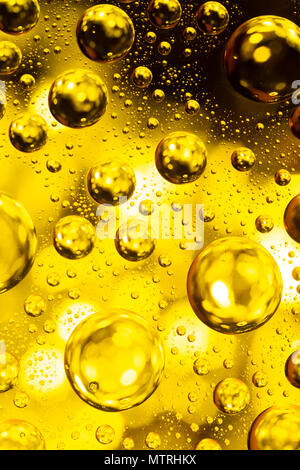 Goutte d'eau sur une vitre avec un arrière-plan lumineux jaune Banque D'Images