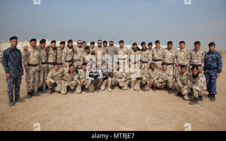 Les formateurs d'espagnol et les forces de sécurité iraquiennes de prendre une photo de groupe à Besmaya Éventail complexe, l'Iraq, le 20 janvier 2017. Besmaya est l'un des quatre Combined Joint Task Force - Fonctionnement inhérents résoudre endroits dédiés à renforcer les capacités des partenaires. Les GFIM-OIR est la Coalition mondiale pour vaincre ISIL en Iraq et en Syrie. (U.S. Photo de l'armée par le Sgt. Joshua Wooten) Banque D'Images