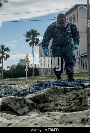 170123-WZ792-033 (janv. 23, 2017)  +101, Floride - Hospital Corpsman 1re classe Dominic L'Admirault d'Entomologie Marine Centre of Excellence (NÉCE) Jacksonville, en Floride, s'applique l'insectifuge perméthrine aux uniformes, à la Station Navale de Mayport, Floride le traitement uniforme est l'un des nombreux membres de préparations avant de partir sur la poursuite de promesse 2017 (CP-17). Promesse continue 2017 est un U.S. Southern Command-parrainé et U.S. Naval Forces Southern Command/U.S. 4ème flotte-déploiement effectué pour mener des opérations civiles et militaires y compris l'aide humanitaire, l'engagement de formation Banque D'Images