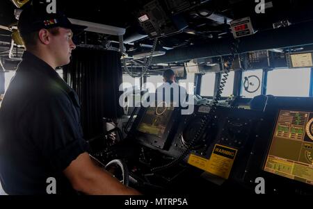 170120-N-RM689-007 OCÉAN PACIFIQUE (jan. 20, 2017) Seaman Brendan Quinn mans la barre en tant que classe Arleigh Burke destroyer lance-missiles USS Wayne E. Meyer (DDG 108) les transits de l'océan Pacifique. Wayne E. Meyer est en fonction d'un programme de déploiement de l'ouest du Pacifique avec le groupe aéronaval du Carl Vinson dans le cadre de la flotte américaine du Pacifique visant à étendre la commande et des fonctions de contrôle de la flotte des États-Unis 3e dans l'Indo-Asia-région du Pacifique. (U.S. Photo par marine Spécialiste de la communication de masse 3 Classe Kelsey L. Adams/libérés) Banque D'Images