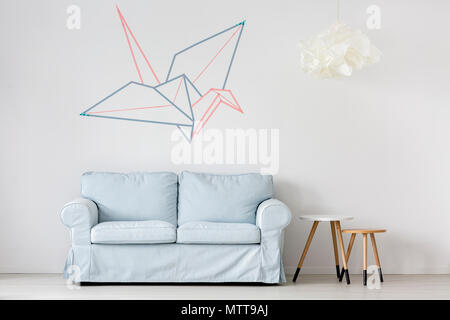 Canapé bleu pastel dans mur blanc prix d'origami Banque D'Images