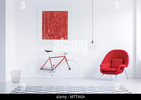 Cycle rouge en blanc avec tapis avec motif géométrique, fauteuil et de l'affiche Banque D'Images