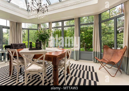 Nouveau style de salle à manger avec table et chaises en bois massif, lustre et système de mur fenêtre Banque D'Images