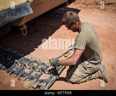 La CPS. Derek étincelles, un mécanicien de véhicules de piste, avec la société D, 106e Bataillon de soutien, enlève un pavé tactile d'un M1A1 Abrams Tank près de Oro Grande N.M., le 21 mai 2018. Les étincelles et son équipage ont été appelés à fixer le réservoir après avoir rompu sa voie sur le chemin de conduite incendie réel. (U.S. La Garde nationale de l'armée photo par le Sgt. Bretagne Johnson.) Banque D'Images