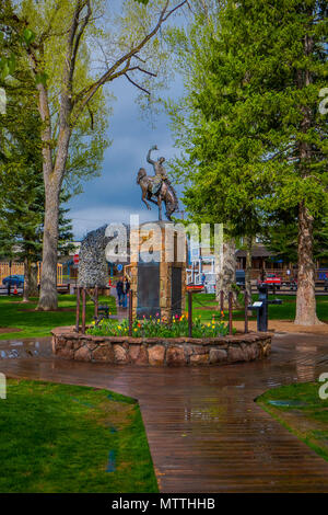 JACKSON Hole, Wyoming, USA - Le 23 mai 2018 : vue extérieure de balades touristiques dans un parc près d'une statue en bronze de cowboy sur cheval à la place de la ville de Jackson Wyoming Banque D'Images