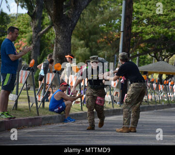 Soldats et chefs affectés à 715 e bataillon de renseignement militaire, le Renseignement militaire 500e Brigade-Theater, honorer nos héros disparus qui ont fait le sacrifice ultime au service de notre pays, en participant à l'Hibiscus le demi-marathon, le 27 mai 2018 à Waikiki, Hawaii. Pendant le demi-marathon, les soldats ont enfilé leur ruck sacs avec photos de héros qu'ils connaissaient personnellement comme ils ont marché et couru la route. Banque D'Images